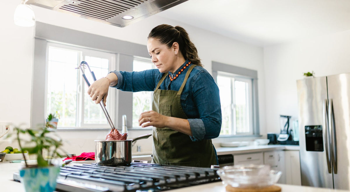 Personne portant un tablier de cuisine et cuisinant en toute sécurité dans une cuisine moderne