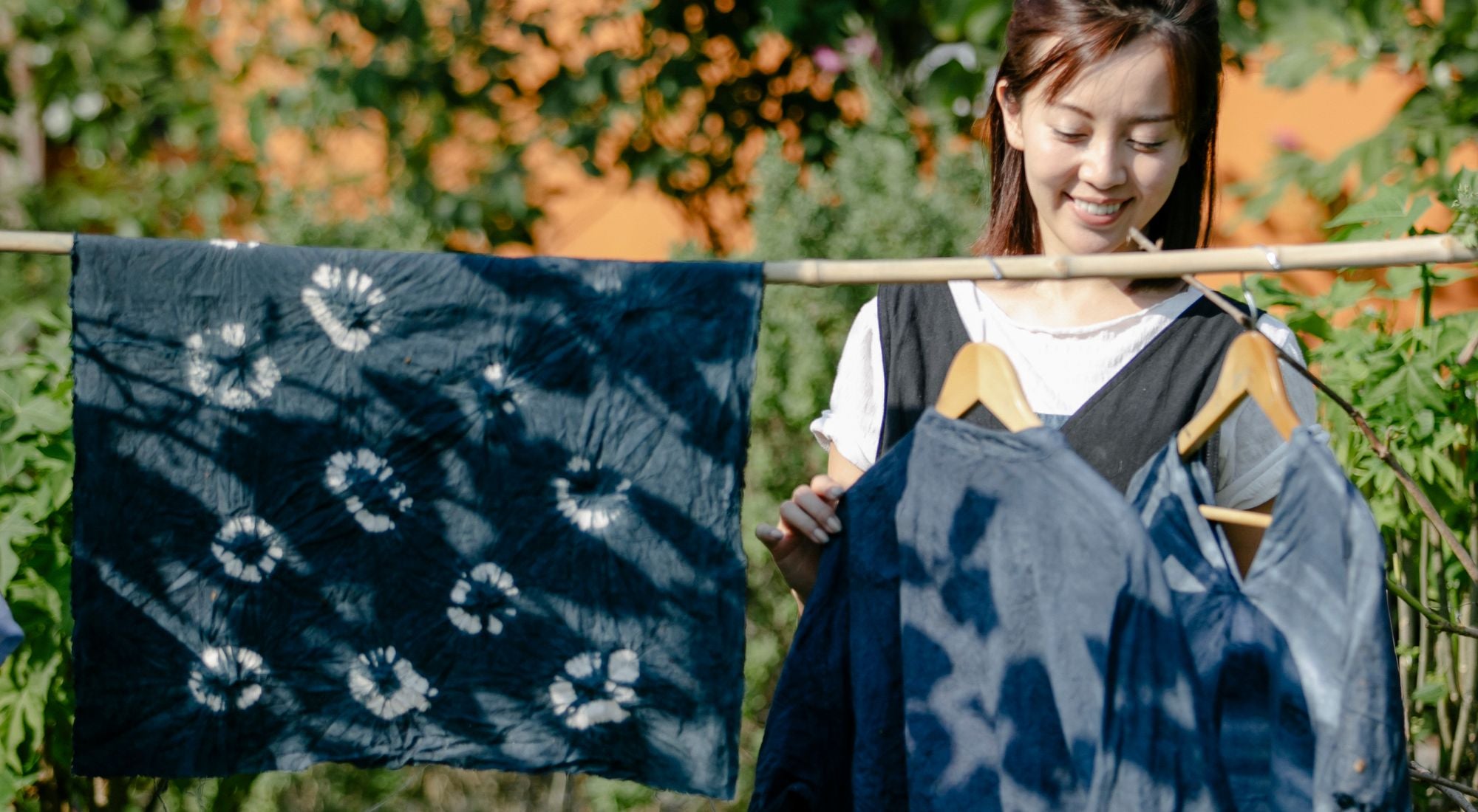 Tablier japonais maekake bleu indigo accroché dans un atelier artisanal