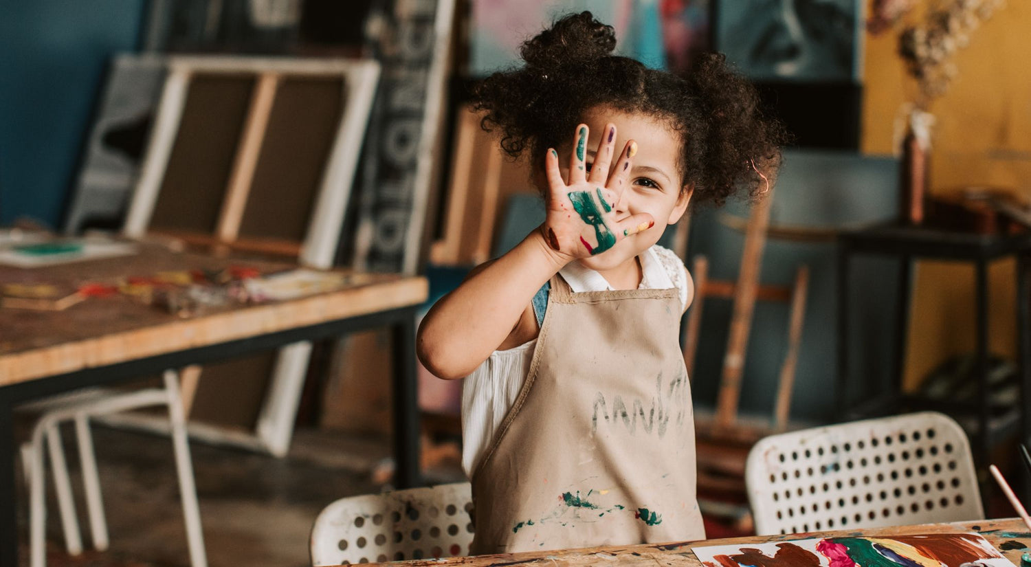 Jeune enfant créatif portant un tablier de peinture lors d'un atelier artistique