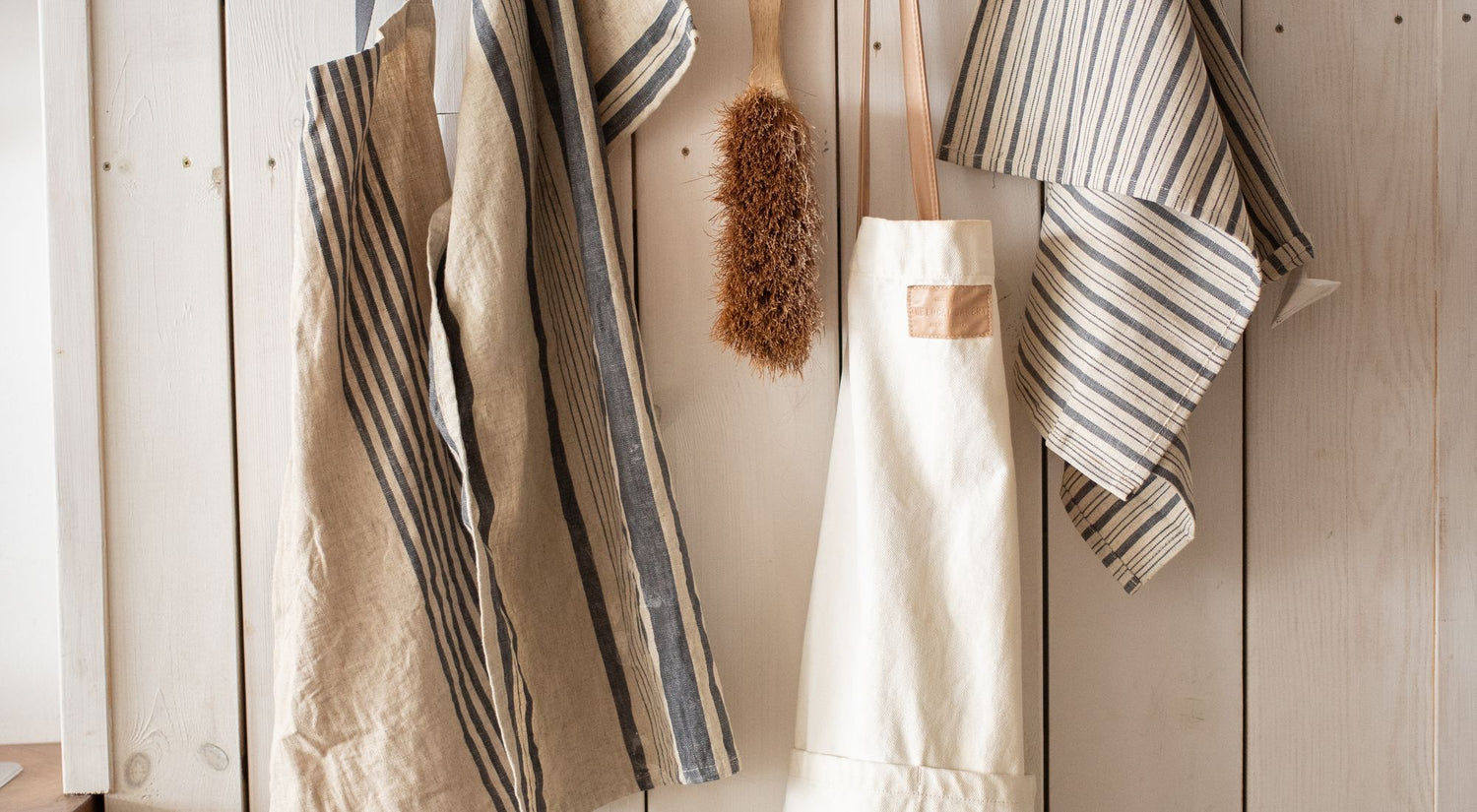 Tablier de cuisine à bavette suspendu à un crochet en bois, vue élégante