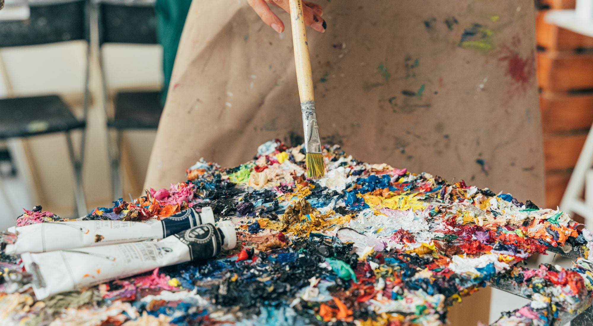Artiste portant un tablier de peinture lors d'une séance créative avec des peintures acryliques