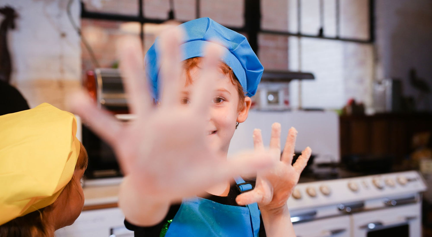 Groupe d'enfants souriants portant des tabliers colorés lors d'un atelier cuisine