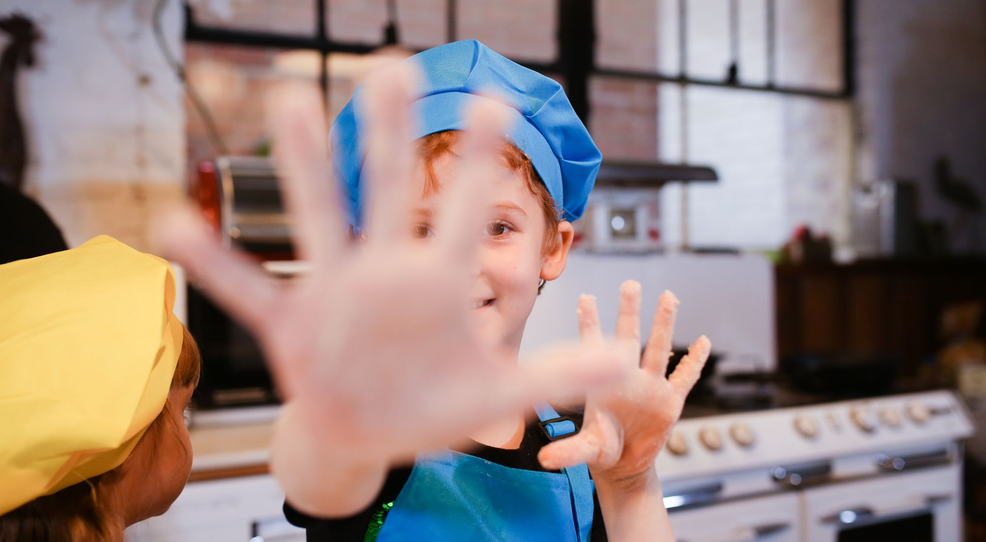 Groupe d'enfants souriants portant des tabliers colorés lors d'un atelier cuisine