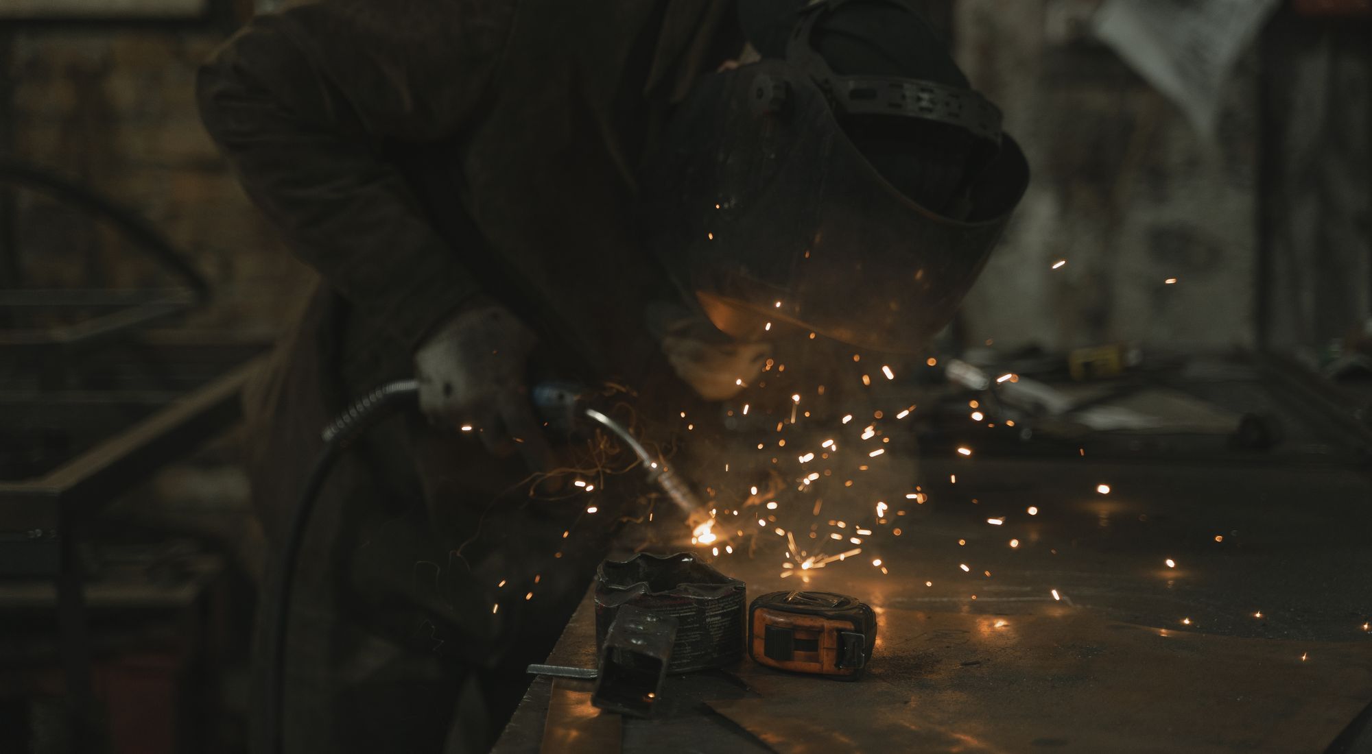 Professionnel équipé d'un tablier de soudure en cuir lors d'une opération de soudage en atelier.