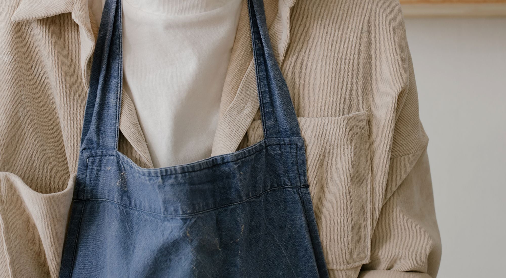 Personne en tablier de cuisine en coton bio cuisinant à la lumière naturelle