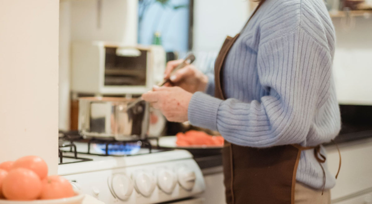 Personne portant un tablier de cuisine bien ajusté devant les fourneaux