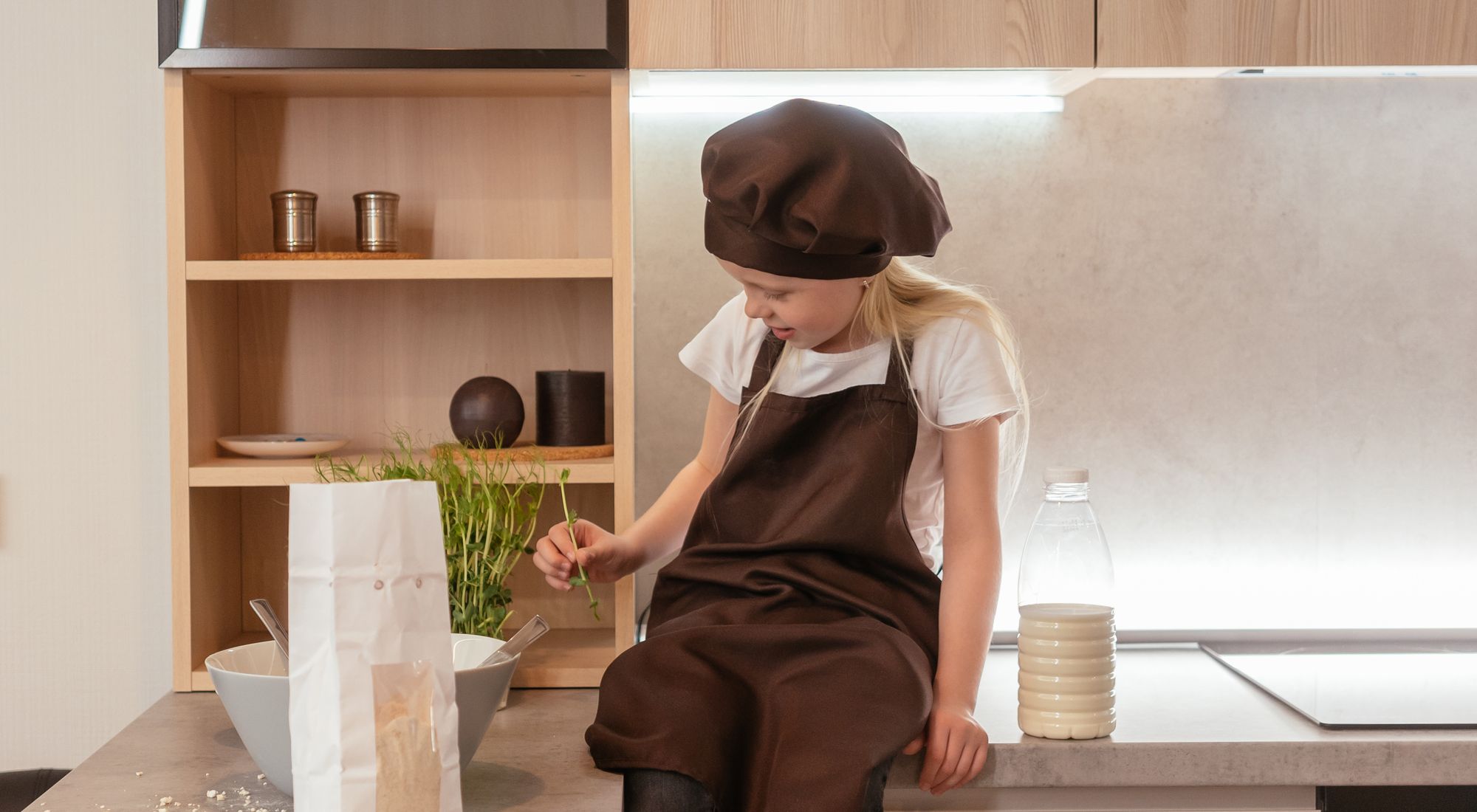 Jeune enfant souriant avec tablier de cuisine, prêt à cuisiner en famille