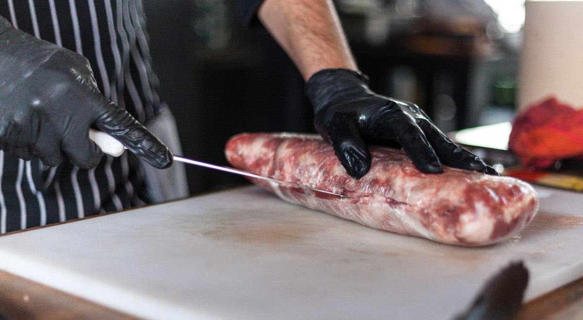 Tablier de boucher professionnel porté au comptoir d'une boucherie artisanale