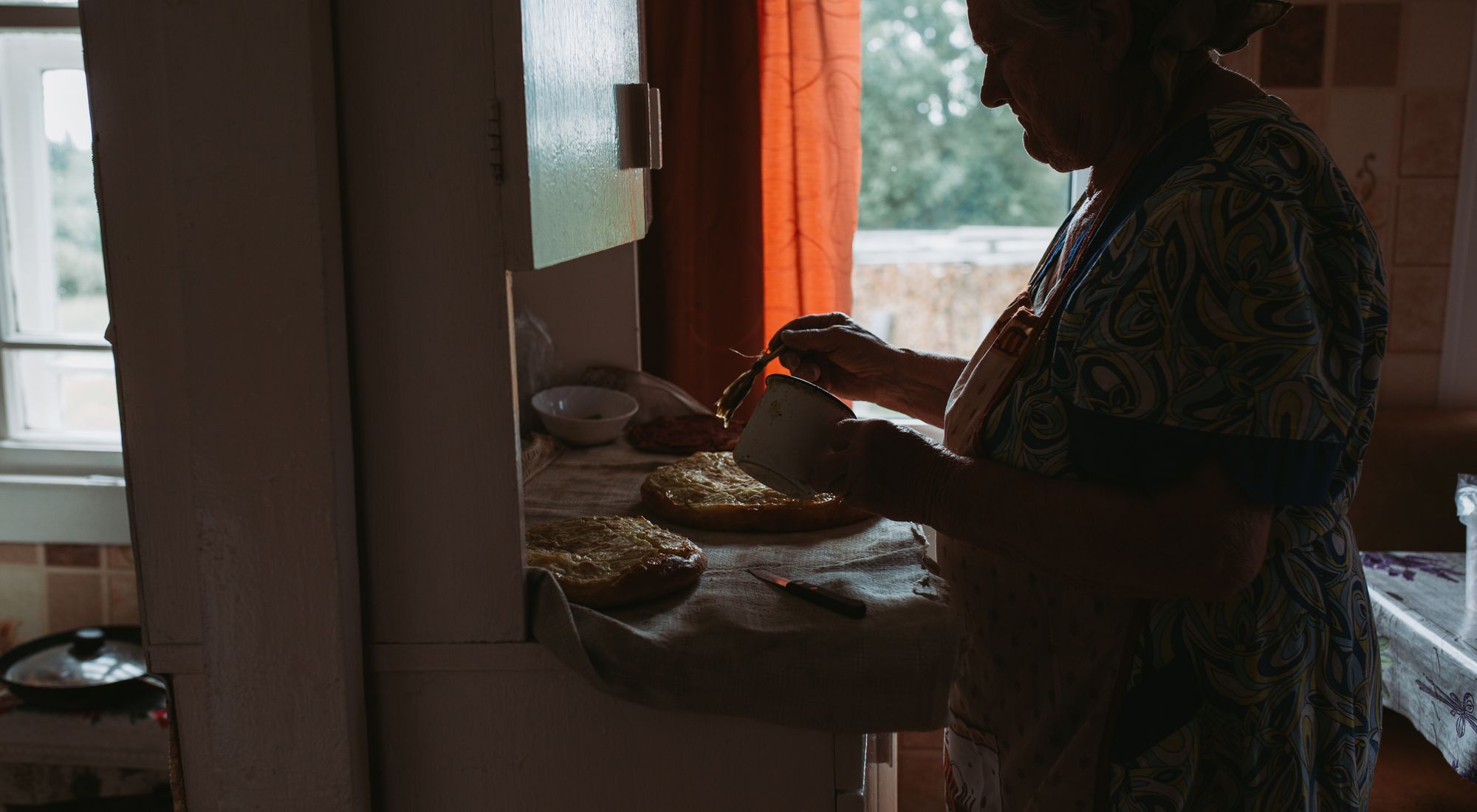 Robe tablier grand-mère portée en cuisine, ambiance chaleureuse et traditionnelle